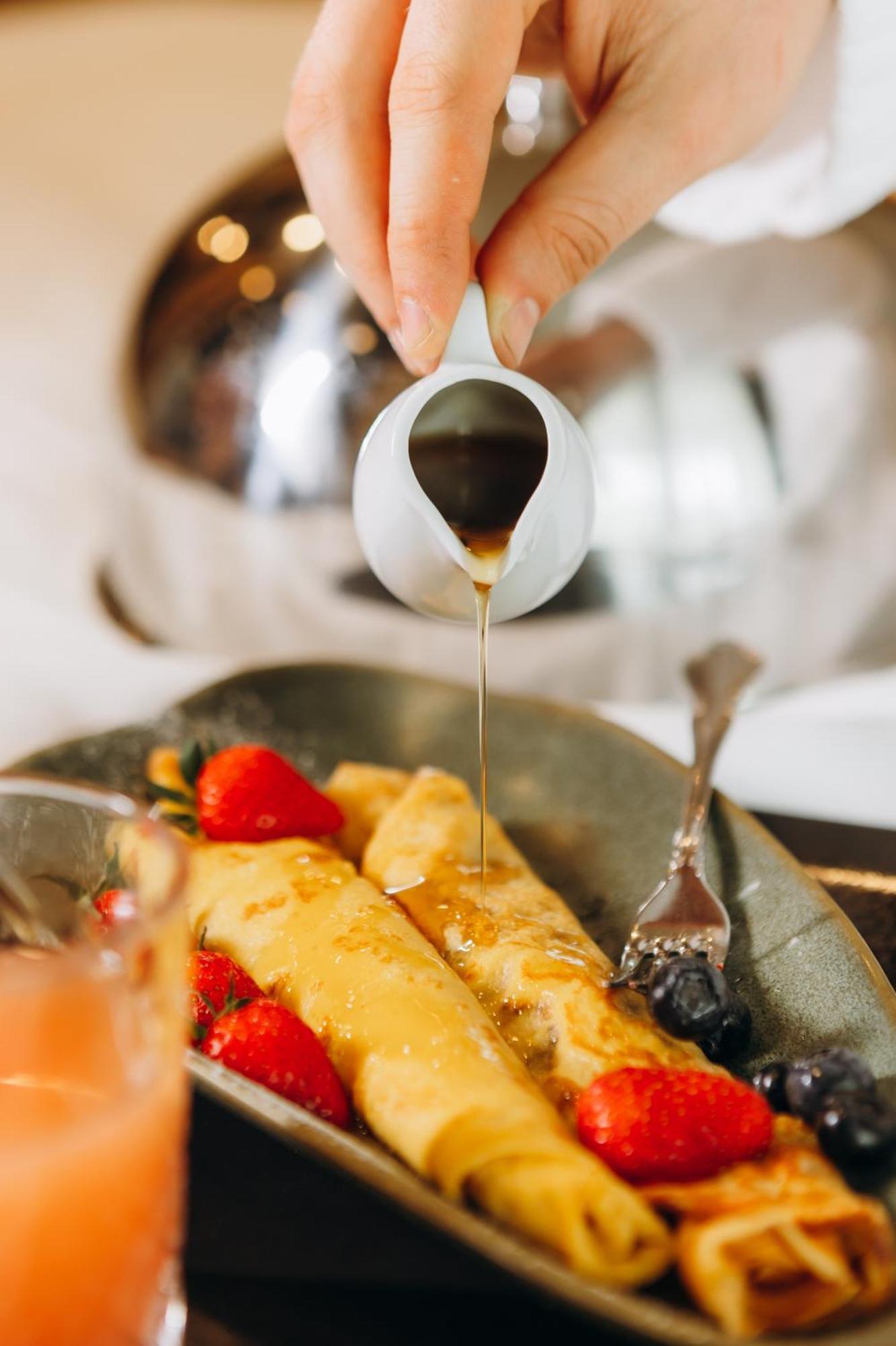 Hotel Platinia Kluż-Napoka Zewnętrze zdjęcie Maple syrup being poured onto crêpes
